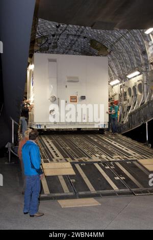 Die Arbeiter führten den Container mit der Juno-Raumsonde der NASA über die Rampe eines C-17-Jets in der Shuttle Landing Facility des Kennedy Space Centers in Florida, bevor sie ihn zu Astrotech-Anlage in Titusville transportierten, um die Struktur, Atmosphäre, Magnetosphäre und den potenziellen festen Kern des Jupiters während 33 polaren Umlaufbahnen zu untersuchen. Stockfoto