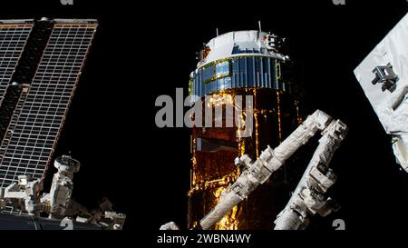 Japans H-II Transfer Vehicle-9 (HTV-9) befindet sich in der Nähe des Canadarm2 Roboterarms, wobei eine der wichtigsten Solarfelder der Internationalen Raumstation sichtbar ist. Stockfoto
