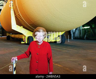 Eine optische Illusion setzt Lady Margaret Thatcher, ehemalige Premierministerin von Großbritannien, unter einen externen Tank im Fahrzeugbau. In Wirklichkeit ist die ET hinter ihr und wartet im Umsteigegang auf das nächste Shuttle. Lady Thatcher ist auf Tour durch KSC Stockfoto