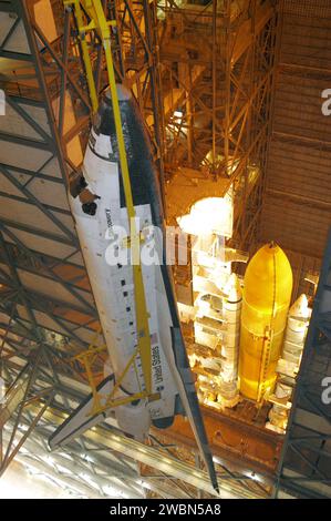 RAUMFAHRTZENTRUM KENNEDY, FLA. - Der Orbiter Discovery wird von einem Deckenkran im Fahrzeugmontagegebäude im Kennedy Space Center der NASA abgesenkt und befindet sich in Richtung Solid Rocket Booster und externer Tank (siehe unten), die bereits auf der Oberseite der Mobile Launcher Platform (MLP) gestapelt sind. Nachdem der Discovery mit der Baugruppe „externer Tank Solid Rocket Booster“ auf dem MLP verknüpft wurde und alle Kabelverbindungen angeschlossen wurden, führen die Arbeiter eine elektrische und mechanische Überprüfung der verbundenen Schnittstellen durch, um alle kritischen Fahrzeugverbindungen zu überprüfen. Ein Shuttle-Schnittstellentest wird mit dem durchgeführt Stockfoto