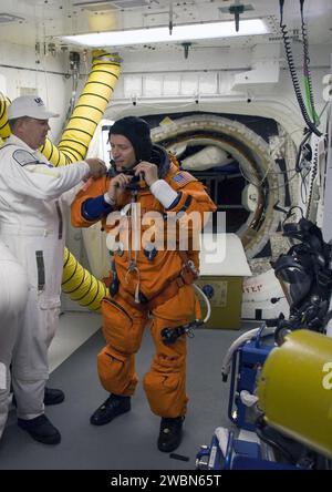 CAPE CANAVERAL, Fla. Im White Room auf der Launch Pad 39A im Kennedy Space Center der NASA in Florida wird STS-125 Pilot Gregory C. Johnson von der Besatzung unterstützt, die sein Gurtzeug auflegt, das einen Fallschirmpack enthält, bevor er durch die offene Luke ins Space Shuttle Atlantis kriecht. Der Weiße Raum befindet sich am Ende des Orbiter-Zugangsarms an der festen Versorgungsstruktur und bietet Zugang zum Shuttle. Atlantis' 11-tägiger Flug umfasst fünf Raumwanderungen, um das Teleskop mit modernsten wissenschaftlichen Instrumenten zu modernisieren und zu erweitern, die Hubbles Fähigkeiten erweitern und i erweitern Stockfoto