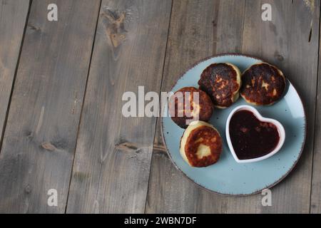 Festliche Morgen Happy Valentine's Day Cheesecakes Pancakes mit Varent und Herz. Niedliches Geschirr mit Platz für Text im Kopierbereich. Stockfoto