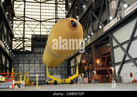 RAUMFAHRTZENTRUM KENNEDY, FLA. - Im Vehicle Assembly Building des NASA Kennedy Space Centers wird der externe Tank 119 auf einen Transporter im Transfergang abgesenkt, der zum Lastkahn am Turn Basin gebracht wird. Der Panzer wird sich auf eine Reise um die Halbinsel Florida begeben, um die Michoud Assembly Facility in New Orleans zu erreichen. ET-119 wurde im Juni an KSC ausgeliefert und ist der dritte neu gestaltete Tank. Stockfoto