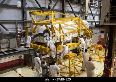 CAPE CANAVERAL, Fla. -- innerhalb der Orbiter Processing Facility-2 im Kennedy Space Center der NASA in Florida helfen Techniker, während ein großer Kran das linke Orbitalmanövriersystem (OMS) von Atlantis auf einen Träger senkt. Die Arbeit ist Teil der Übergangs- und Pensionierung des Shuttles Atlantis. Die OMS-Pods werden nach White Sands Space Harbor in New Mexico geschickt, wo sie einer vollständigen Deservicing- und Reinigungsaktion unterzogen und dann nach Kennedy zurückgegeben werden, um sie auf Atlantis wieder zu installieren. Atlantis wird für die Ausstellung im Kennedy Space Center Visito vorbereitet Stockfoto