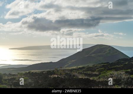 Die ruhigen Hügel von Maui sonnen sich im Glanz der untergehenden Sonne und bieten einen ruhigen Blick auf das Meer, der die unberührte Schönheit der Insel einfängt. Stockfoto