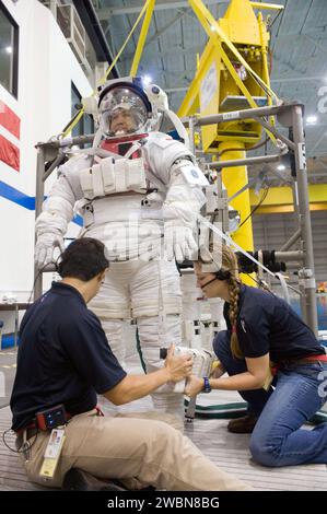 JSC2012-E-208824 (15. August 2012) --- Japan Aerospace Exploration Agency (JAXA) Astronaut Koichi Wakata, Flugingenieur der Expedition 38 und Kommandeur der Expedition 39, bekommt Hilfe beim Anziehen einer Trainingsversion seines Raumanzugs der Extravehicle Mobility Unit (EMU) in Vorbereitung auf ein Raumspaziertraining in den Gewässern des Neutral Booyancy Laboratory (NBL) in der Nähe des Johnson Space Center der NASA. Stockfoto