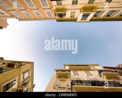Flacher Blick auf den blauen Himmel zwischen Gebäuden in einer engen Straße Stockfoto