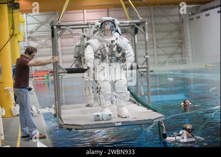 JSC2011-E-054076 (13. Juni 2011) --- die NASA-Astronauten Sandy Magnus und Rex Walheim (meist verdeckt), beide STS-135-Missionsspezialisten, die in Trainingsversionen ihrer EMU-Raumanzüge (ExtraVehicular Mobility Unit) bekleidet sind, werden kurz davor in den Gewässern des Neutral Booyancy Laboratory (NBL) in der Nähe des Johnson Space Center der NASA untergetaucht. Taucher sind im Wasser, um Magnus und Walheim bei der Probe zu helfen. Stockfoto