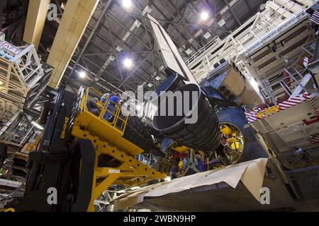 Die Arbeiter des Kennedy Space Centers der NASA positionieren mit einem Hyster-Gabelstapler ein nachgebildetes Shuttle-Haupttriebwerk in den Triebwerkbrunnen des Space Shuttle Discovery. Das Triebwerk ist Teil der Vorbereitungen für die Ausstellung im National Air and Space Museum des Smithsonian. Stockfoto
