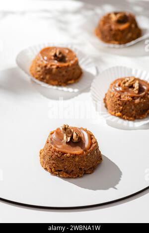 Kuchen Sie einen Korb mit Schokoladenkondensmilch und Nüssen auf weißem Hintergrund. Stockfoto