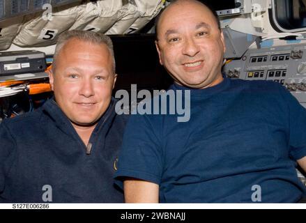 S127-E-006286 (16. Juli 2009) --- die Astronauten Mark Polansky (rechts), STS-127-Kommandeur; und Doug Hurley, Pilot, nehmen sich einen Moment für ein Foto auf dem Flugdeck des Space Shuttle Endeavour während der Aktivitäten des zweiten Fluges. Stockfoto