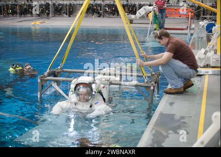 JSC2011-E-054089 (13. Juni 2011) -- - die NASA-Astronauten Rex Walheim und Sandy Magnus (meist verdeckt), beide STS-135-Missionsspezialisten, die in Trainingsversionen ihrer ExVehicular Mobility Unit (EMU)-Raumanzüge bekleidet sind, werden aus dem Wasser des Neutral Booyancy Laboratory (NBL) in der Nähe des Johnson Space Center der NASA aufgerichtet, als ein Raumwanderungstraining zu Ende geht. Taucher waren im Wasser, um Magnus und Walheim bei der Probe zu unterstützen. Stockfoto