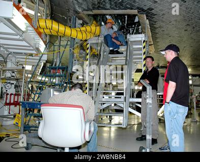 In der Orbiter Processing Facility der NASA, Bucht 1, inspiziert Charles Wassen die Hauptlenkereinheit von Atlantis mit einem Boroskop. Der Werkstoffingenieur Dave Rumpf überwacht die Ergebnisse, während Jessie McEnulty und Tony Glass helfen. Das mechanische Gestänge senkt die Fahrgetriebetüren ab, die in 10 Sekunden vollständig ausgefahren und mit federbelasteten Dämpfer verriegelt werden. Atlantis wird im September 2005 zur Mission STS-121 zurückkehren. Stockfoto