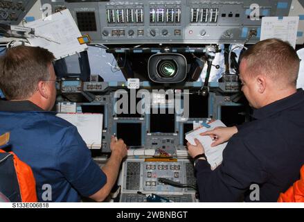 S133-E-006818 (26. Februar 2011) --- NASA-Astronauten Steve Lindsey (links), STS-133-Kommandeur; und Eric Boe, Pilot, besetzen ihre jeweiligen Stationen auf dem Flugdeck des Space Shuttle Discovery während der Aktivitäten des dritten Fluges. Stockfoto