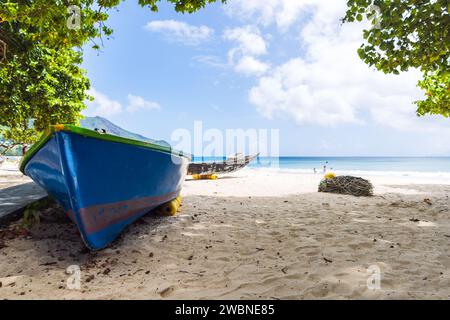 Blaues Boot liegt auf dem Sand von Beau Vallon Beach an einem sonnigen Tag, Seychellen Stockfoto