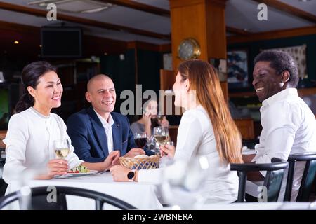 Positive Gäste, die im Café essen und trinken Stockfoto