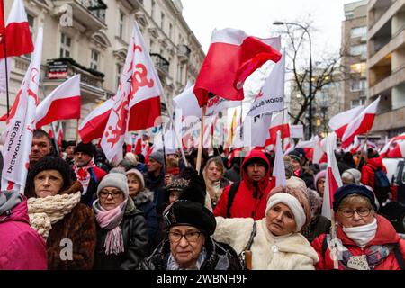 Warschau, Polen, 11. Januar 2024. Menschenmassen, die die polnische Nationalflagge halten und von Recht und Gerechtigkeit (Prawo i Sprawiedliwość - PIS) geführt werden, protestieren vor dem polnischen Parlamentsgebäude gegen Veränderungen in den öffentlichen Medien in Polen und zum Schutz der Demokratie, sagen Politiker der PIS. Die Partei Recht und Gerechtigkeit herrschte acht Jahre in Polen, bis sie die letzte Wahl im Oktober 2023 verlor. Die Partei wird nun zu einer rechten Oppositionstruppe gegen eine stärker zentristische und liberalere Regierungskoalition, wo die wichtigste politische Kraft die Civic Coalition unter der Führung von Donald Tusk, dem ehemaligen Presi, ist Stockfoto