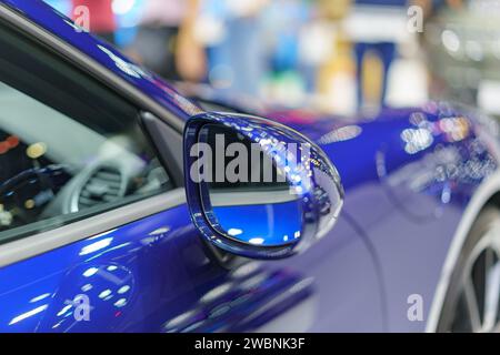 Die Nahaufnahme mit dem eleganten blauen Seitenspiegel einer modernen reflektierenden Oberfläche des Autos und dem stromlinienförmigen Design versprüht einen modernen Stil und verkörpert den Stockfoto