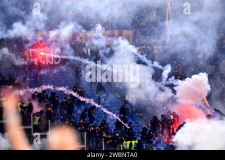 Lazio und Roma-Fans werfen sich beim italienischen Fußballspiel zwischen SS Lazio und AS Roma im Olimpico-Stadion in Rom (Italien) am 10. Januar 2024 gegenseitig Fackeln und Rauchgranaten. Stockfoto