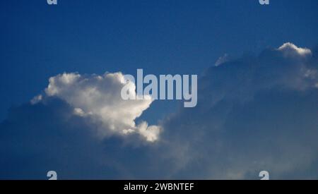 Blauer Himmel und Wolken, Lichtschichten, die durch die Wolken brechen, die sich übereinander übereinander überlagern. Ich schaue nur nach oben, bis zum Himmel, ohne Horizont Stockfoto