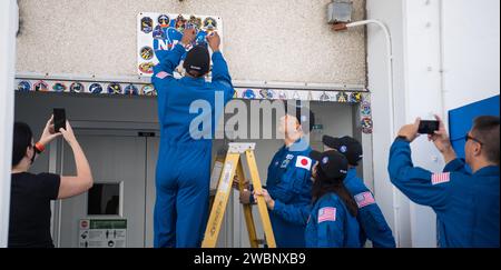 NASA-Astronaut Victor Glover, links auf der Leiter, platziert einen Aufkleber für die Crew-1-Mission über der Tür zu den Crewquartieren im Neil A. Armstrong Operations and Checkout Building als Teamkollegen Astronauten Soichi Noguchi von der Japan Aerospace Exploration Agency (JAXA). und Shannon Walker und Mike Hopkins von der NASA schauen sich am Donnerstag, den 12. November 2020, im Kennedy Space Center der NASA in Florida an. Die SpaceX Crew-1-Mission der NASA ist die erste Crew-Rotationsmission der SpaceX Crew Dragon und der Falcon 9-Rakete zur Internationalen Raumstation im Rahmen des Commercial Crew Program der NASA. Glover Stockfoto