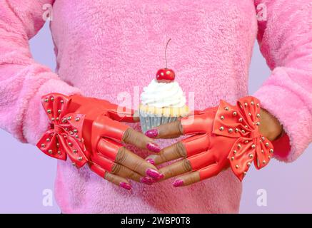 Eine vielseitige afroamerikanische Frau mit Nieten-roten Modeschandschuhen und Einem Vanilla Frosted Cupcake mit einer Kirsche oben Stockfoto