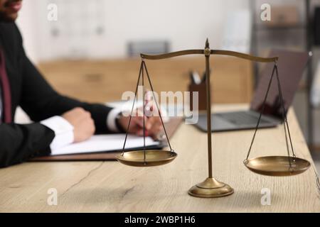 Anwalt arbeitet am Tisch im Büro, konzentriert sich auf die Maßstäbe der Gerechtigkeit Stockfoto