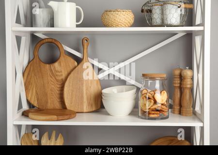 Schneidebretter aus Holz, Geschirr, Küchenutensilien und französische palmier-Kekse auf dem Regal Stockfoto