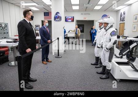 Hinter dem Seil SpaceX CEO und Chefdesigner Elon Musk (links) und NASA-Administrator Jim Bridenstine begrüßen die NASA-Astronauten Robert Behnken (links) und Douglas Hurley im Astronaut-Crew-Quartier im Neil A. Armstrong Operations and Checkout Building im Kennedy Space Center der NASA in Florida vor der Mission SpaceX Demo-2. Der Start, der ursprünglich für den 27. Mai 2020 geplant war, wurde aufgrund ungünstiger Wetterbedingungen um den Launch Complex 39A abgeschrubbt Der nächste Startversuch findet am Samstag, dem 30. Mai statt. Der Start der SpaceX Falcon 9-Rakete und der Crew Dragon ist geplant Stockfoto