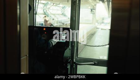 U-Bahn, Fahrer und Cockpit des Zuges im Transport-, Service- und Steuerpult im japanischen Eisenbahnkabinett. Metro, Reise und Mann in der Kabine mit Uniform Stockfoto