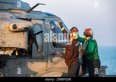 U.S. Navy Aviation Ordnanceman 3. Klasse Michaela Youngquist, links, und der Aviation Electronics Technician 3rd Class Jaxon Webb bereiten einen MH-60S Sea Hawk Hubschrauber vor, der an den 'Dusty Dogs' der Helicopter Sea Combat Squadron (HSC) 7 befestigt ist, für den Flugbetrieb an Bord des Flugzeugträgers USS Dwight D. Eisenhower (CVN 69) im Arabischen Golf vom 5. Dezember 2023. Die Dwight D. Eisenhower Carrier Strike Group wird im Einsatzgebiet der 5. US-Flotte eingesetzt, um die Sicherheit und Stabilität im Nahen Osten zu unterstützen. (Foto der U.S. Navy von Mass Communication Specialist 3rd Class Janae Chambers) Stockfoto