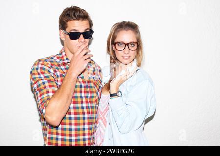 Porträt von coolem Paar auf Party, Sonnenbrille auf Gesicht und Gen z Mode mit Universitätskultur in der Jugend. Nerd-Studenten, Frau und Mann im verrückten Bild Stockfoto