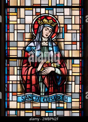 Heilige Elisabeth von Ungarn (von Thüringen). Ein Buntglasfenster in der Eglise de la Sainte-Trinité (Heilige Dreifaltigkeitskirche) in Walferdange, Luxemburg. Stockfoto