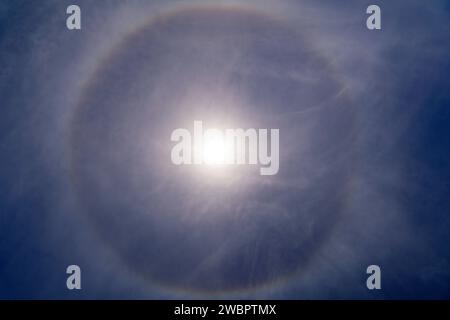 Fantastisches, wunderschönes Sonnenlicht-Phänomen am blauen Himmel. Regenbogen in Form eines Kreises um die Sonne. Stockfoto