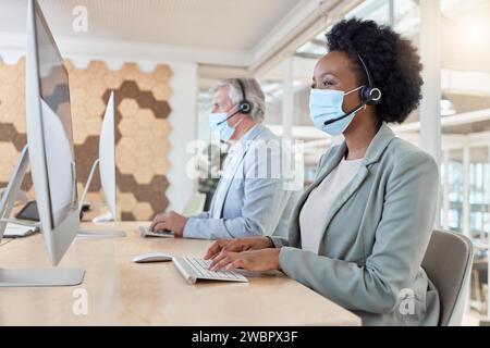 COVID, Masken und Callcenter-Agenten in Compliance, die als Team für Kundenservice in einem Büro arbeiten. Computer, Berater und Telemarketing Stockfoto