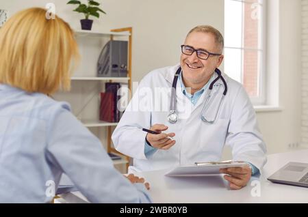 Patientin besucht während der ärztlichen Untersuchung einen freundlichen Arzt in der Praxis. Stockfoto