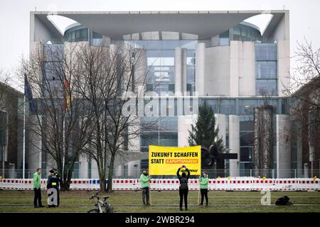 Protest Greenpeace - Zukunft schaffen statt Kaputtsparen DEU, Deutschland, Deutschland, Berlin, 13.12.2023 Demonstranten von Greenpeace mit transparenter Zukunft schaffen statt Kaputtsparen gegen Kuerzungen im sozialen Bererich und beim Klimaschutz bei den Beratungen zum Haushalt vor dem Kanzleramt im Regierungsviertel in Berlin Deutschland. Die Koalition von Bundeskanzler Olaf Scholz hat in letzter Minute eine Einigung erzielt, um die Haushaltsblockade zu beenden, nachdem ein Urteil des Bundesverfassungsgerichts Ihre Ausgabenplaene afuer ungueltig erklaert und sie in eine Krise gestuerzt hatte en: Stockfoto