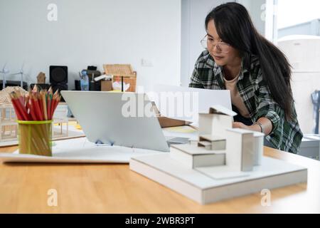 Junge Ingenieurin, die Blaupausen macht. Stockfoto