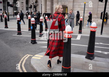 Stadtarbeiter gehen an neuen Straßenpfollern vorbei, nachdem sie am 11. Januar 2024 in London, dem Finanzviertel der Hauptstadt, die Threadneedle Street gegenüber der Bank of England verbreitert haben. Stockfoto