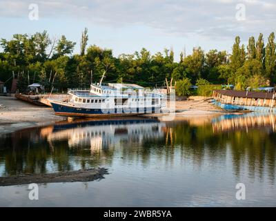 Flussspaß-Ausflugsschiff am Ufer nach der Dnieper-Erschütterung Stockfoto