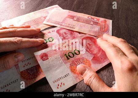 Geld zählen, chinesischer Yuan in Händen. Das Konzept der chinesischen Finanzen und Wirtschaft. Selektiver Fokus. Stockfoto