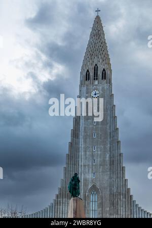 Äußere der berühmten Pfarrkirche Hallgrimskirkja mit geometrischen Elementen in der Nähe der Leif Erikson-Statue unter bewölktem, düsteren Himmel in Reykjavik Stockfoto