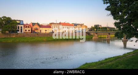 Uhgorod, ukraine - 11. JUN 2017: Stadtbild mit Fluss uzh. Damm der Innenstadt mit alten Gebäuden am anderen Ufer in der Ferne. Sonniger Sommer Stockfoto