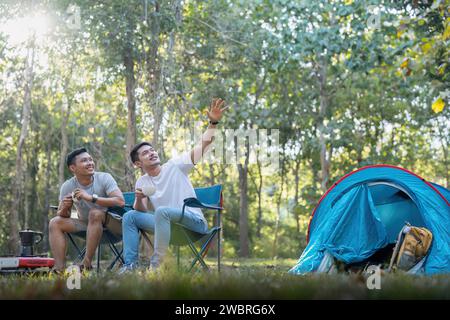 Männliches Schwulenpaar asiatisch reist mit Zelt Camping im Freien und verschiedene Abenteuer Lifestyle Wandern aktiver Sommerurlaub. Kaffee trinken und reden Stockfoto