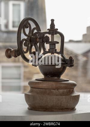 Original Kaffeebohnen-Original-Mahlwerk aus Metall mit Handkurbel. Alte originale Kaffeemühle mit Spuren von Zeit und Abrieb am Körper, Space Stockfoto