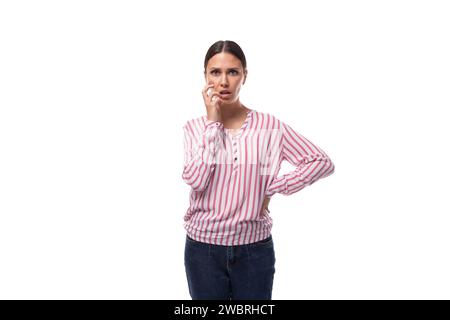Die junge Büroangestellte in einem rosa-weißen Hemd steht überrascht auf weißem Hintergrund Stockfoto