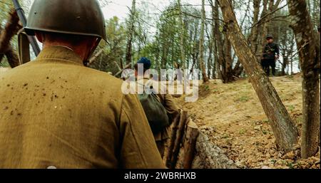 Wiederaufbau Der Schlachten Des Zweiten Weltkriegs. Als sowjetische russische Soldaten verkleidete Reenactoren nehmen Kampfpositionen in Gräben ein. Positionsschutz Stockfoto
