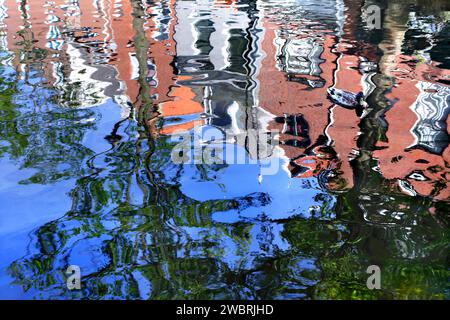 Reflexionen in einem Kanal aus Gebäuden und Bäumen auf einer Straße in der Nähe des Stadtzentrums von Delft. Stockfoto