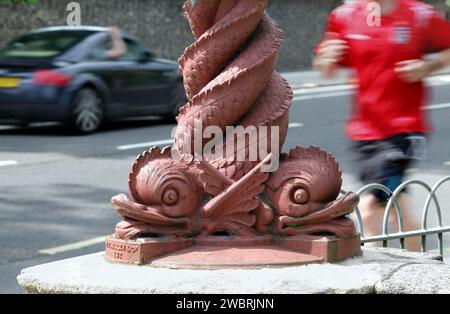 Die Basis einer Lampe, die wie drei verschränkte Meeresbewohner geformt ist, Preston Park, Brighton. (Der dritte ist hinten außer Sichtweite.) Stockfoto