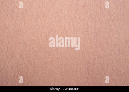 Textur aus Filz mit sichtbarer Faser und abstraktem Muster in pfirsichrosa Farbe Stockfoto